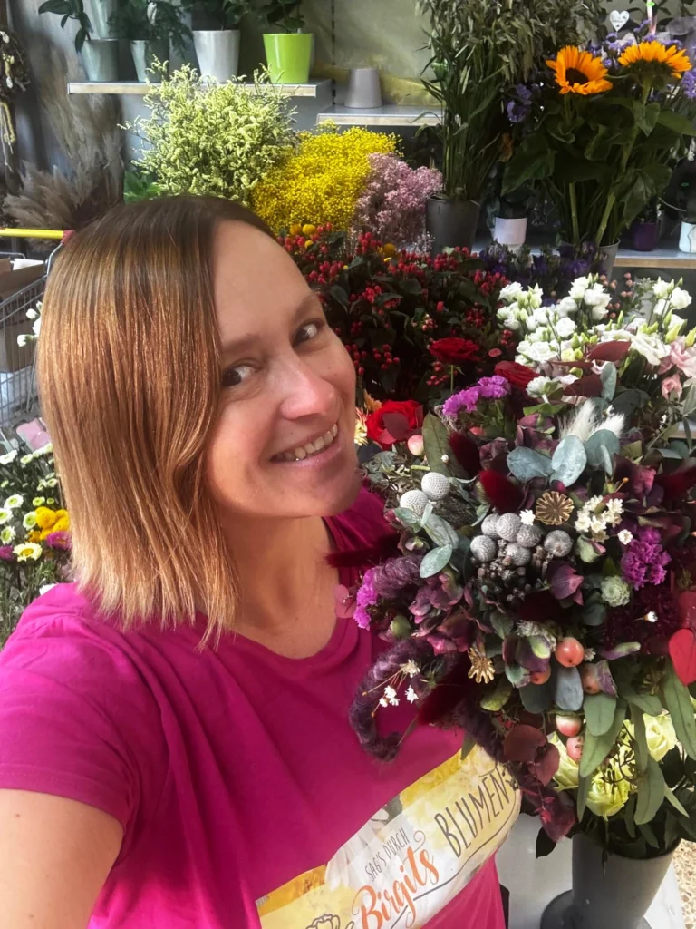 Birgit im Blumenladen zwischen Blumen und Pflanzen